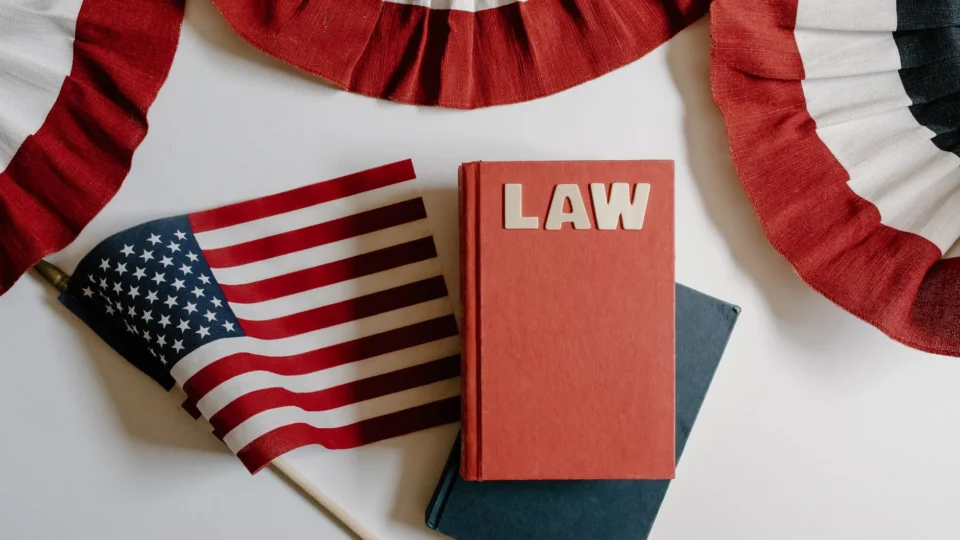 American flag with a law book, symbolizing independence and politics.