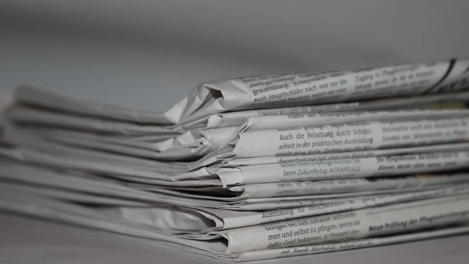A close-up image of folded newspapers, perfect for news or journalism themes.