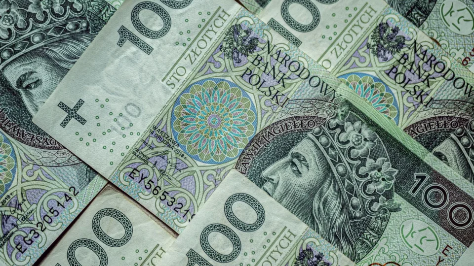 Close-up of multiple Polish 100 Zloty banknotes forming a financial background.