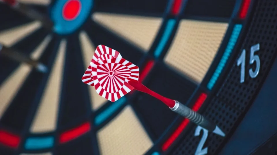 A dart striking the bullseye on a dartboard, showcasing precision and accuracy.