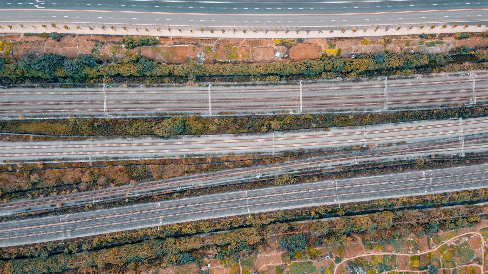 Aerial photo showcasing intersecting railway tracks and roads, highlighting transportation infrastructure.