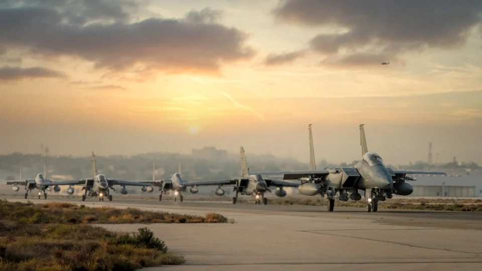 Line of military fighter jets ready for takeoff during a scenic sunset.