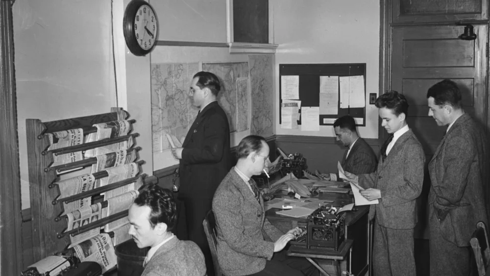 Journalists and editors working in a mid-century CBC newsroom in Montreal