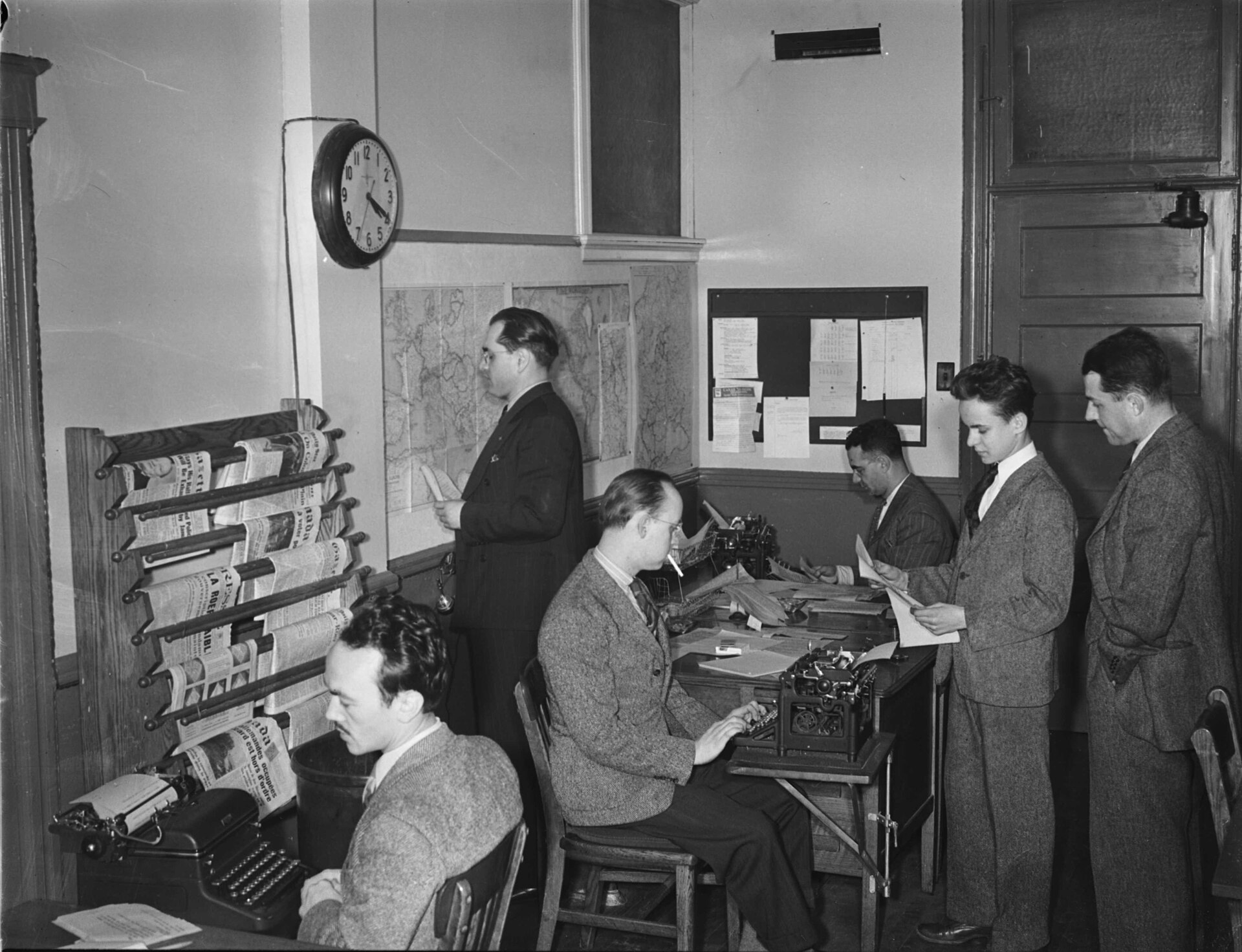 Journalists and editors working in a mid-century CBC newsroom in Montreal