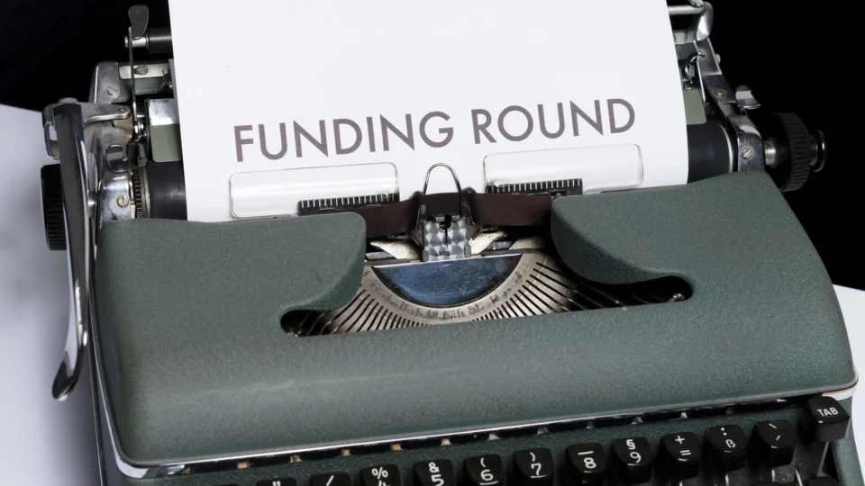 A vintage typewriter displaying the text 'Funding Round,' symbolizing investment and business planning.
