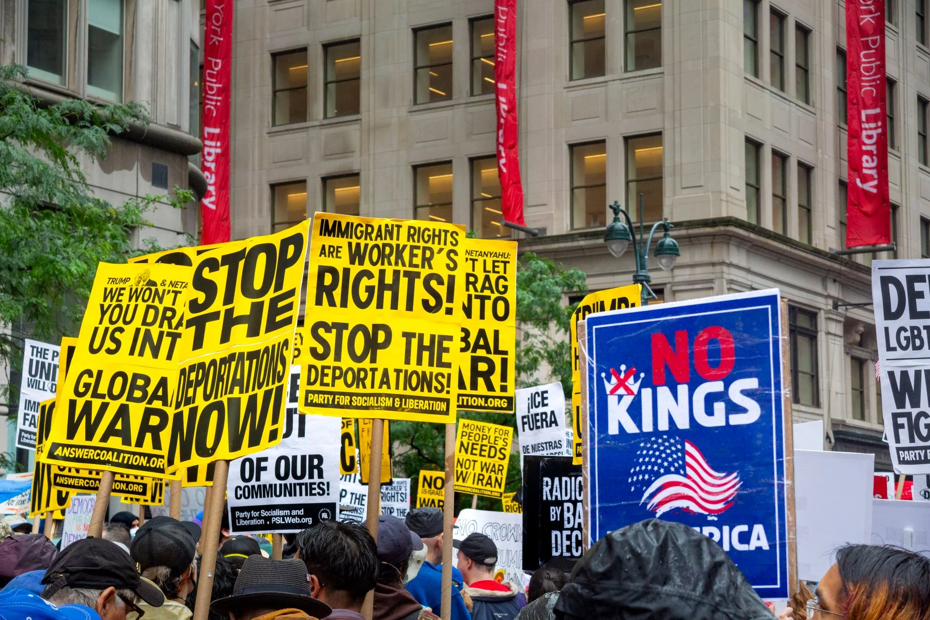 Vibrant protest with signs demanding rights and opposing deportations.