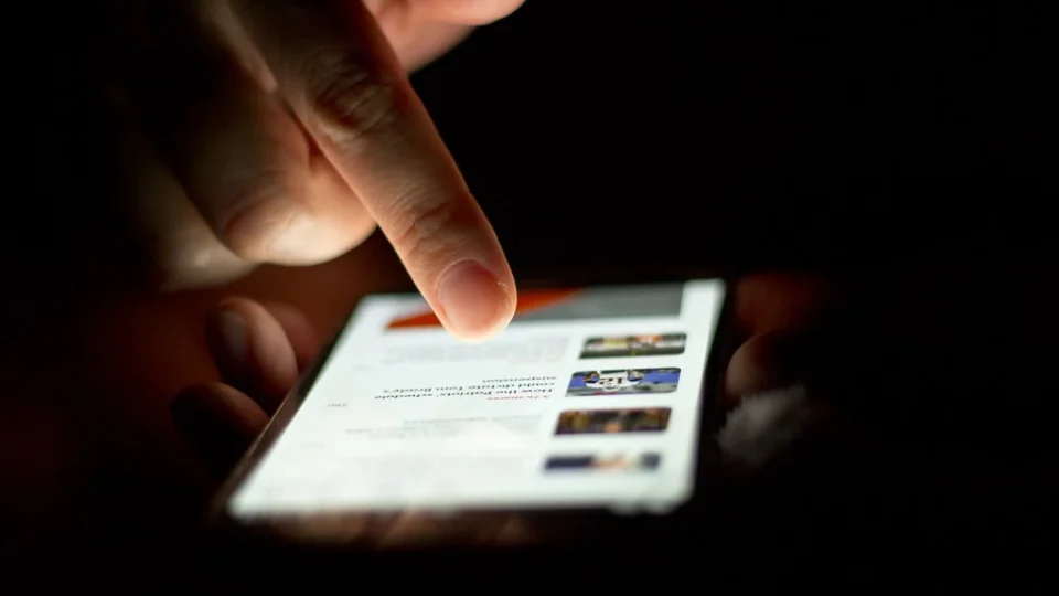 Hands scrolling a news feed on a smartphone
