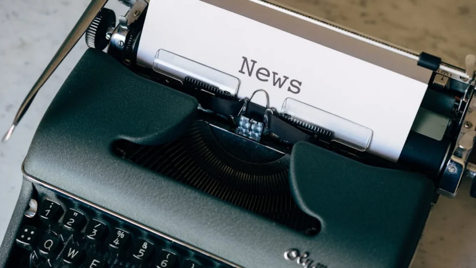 Green and white typewriter on brown wooden table