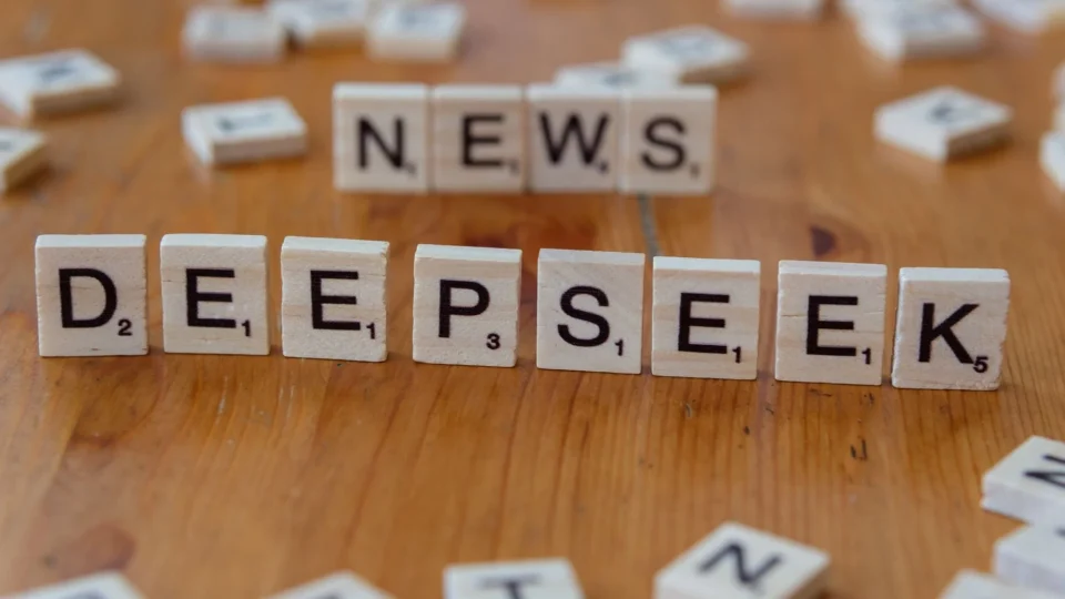 Scrabble tiles spelling 'Deepseek' on a wooden table, emphasizing inquiry and exploration.