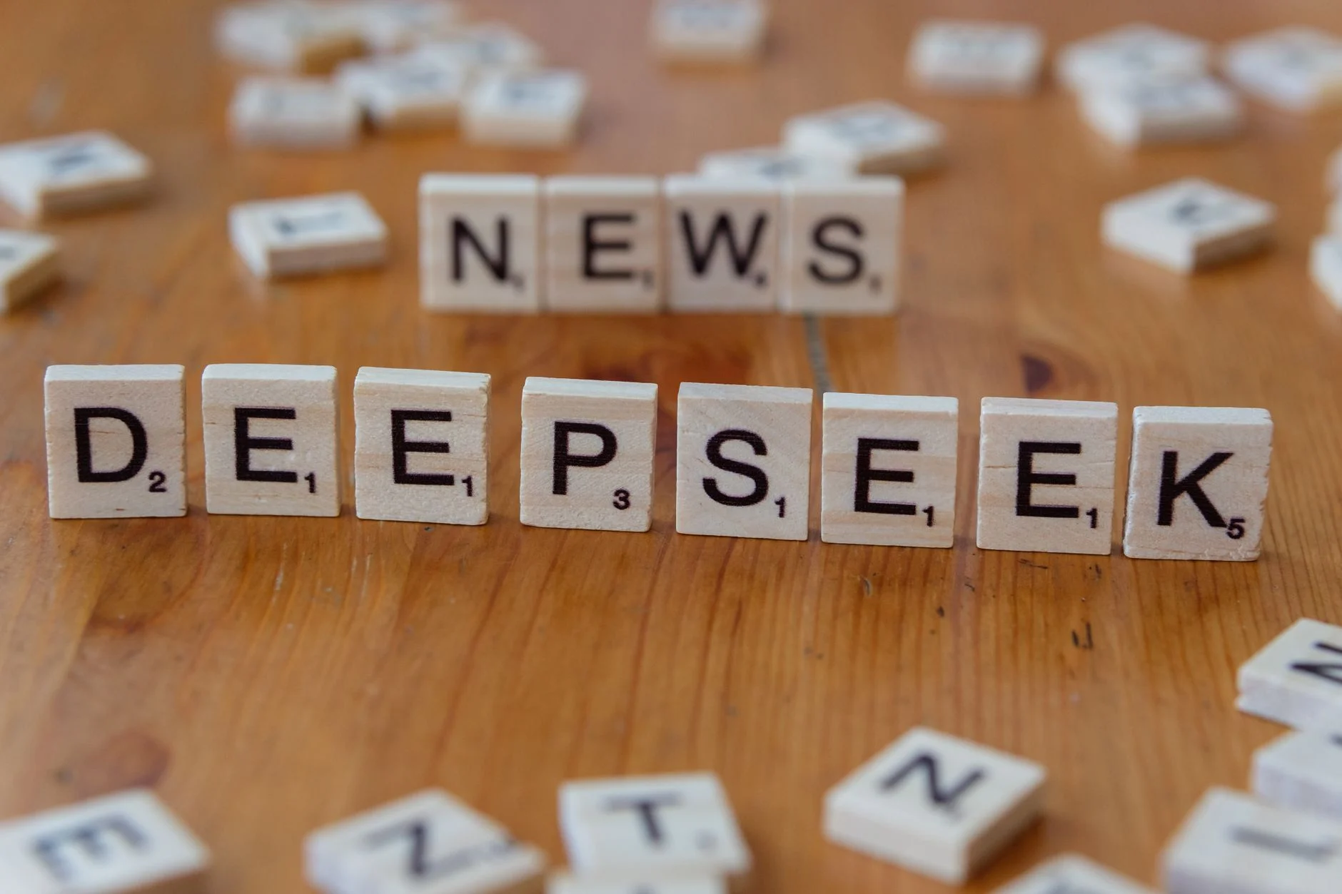 Scrabble tiles spelling 'Deepseek' on a wooden table, emphasizing inquiry and exploration.