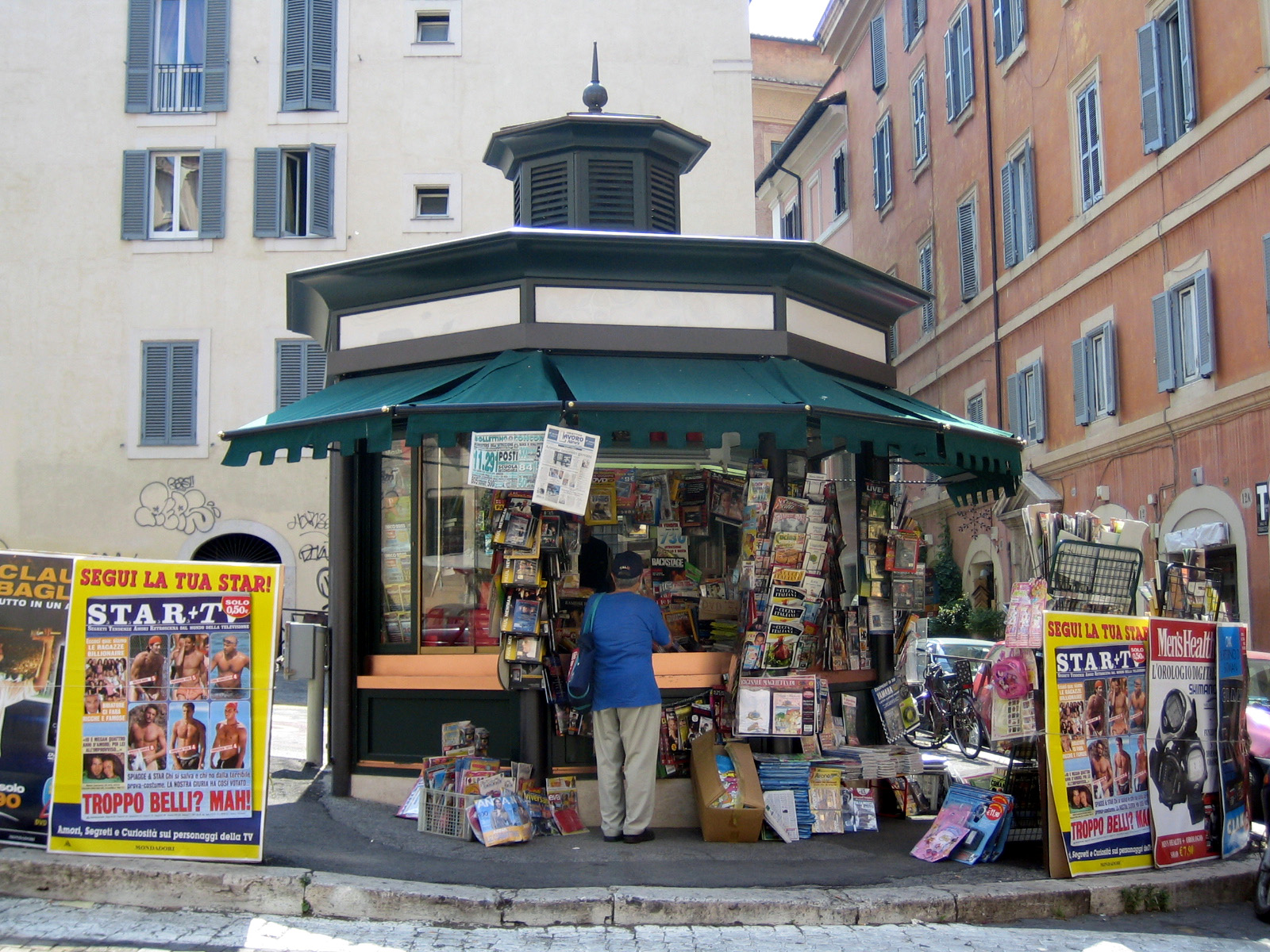 Street newsstand stocked with newspapers and print magazines