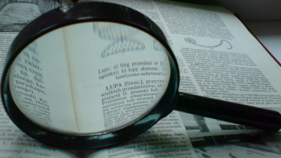 Magnifying glass held over the page of a book