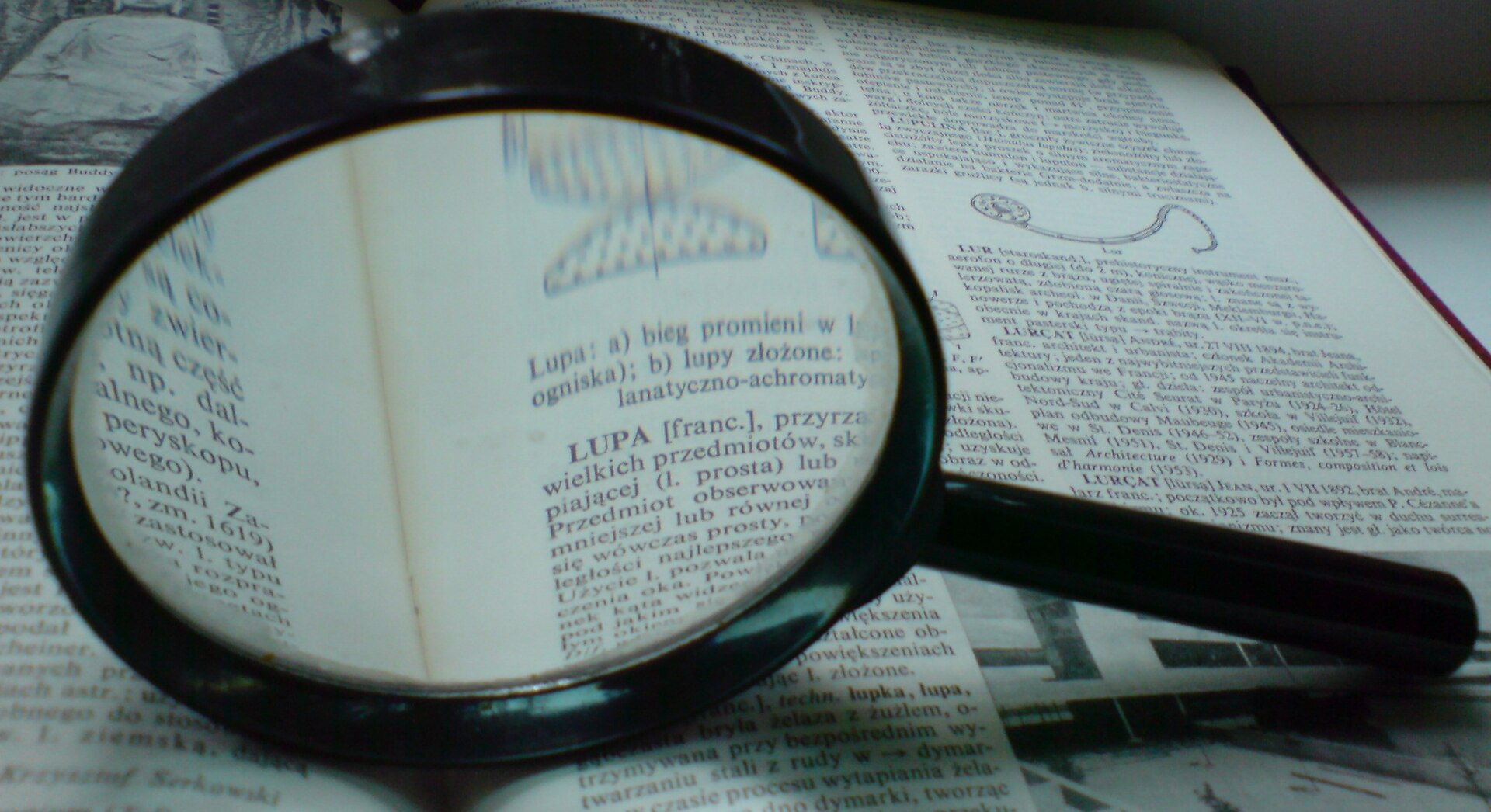 Magnifying glass held over the page of a book