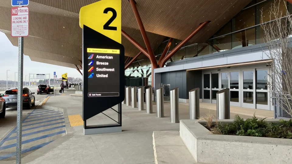 Cars lined up at an airport terminal passenger drop-off zone