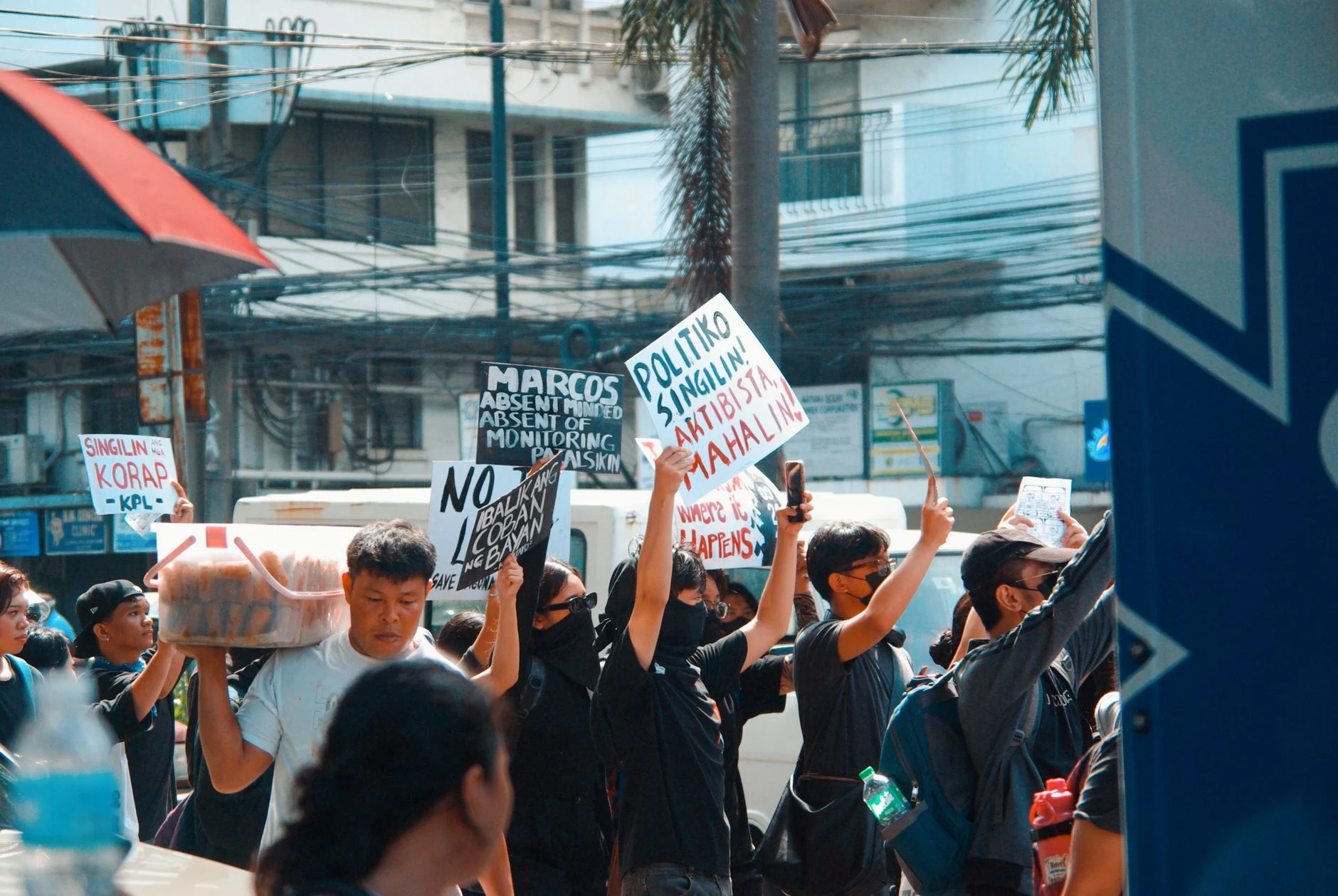 A vibrant urban protest scene with demonstrators holding signs, expressing political messages.