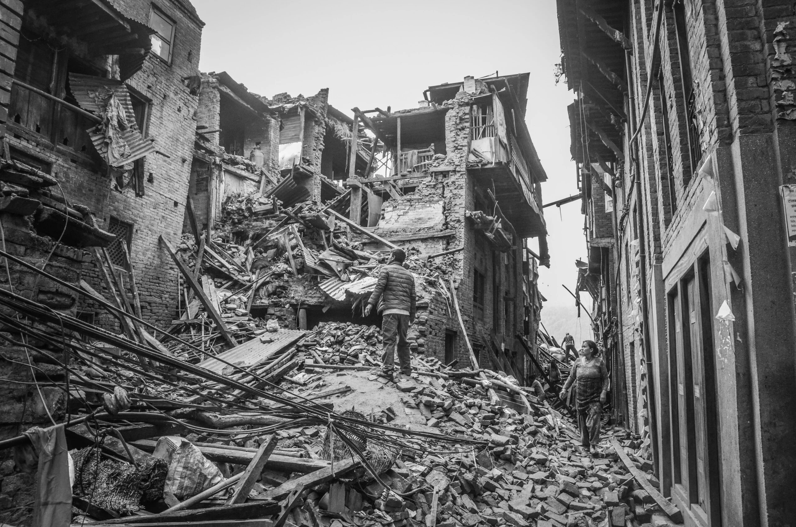 Rubble and destruction in Bhaktapur, Nepal, post-earthquake, capturing the aftermath and human resilience.