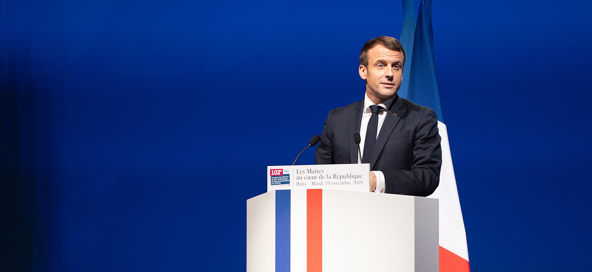 French President Emmanuel Macron speaking at a podium
