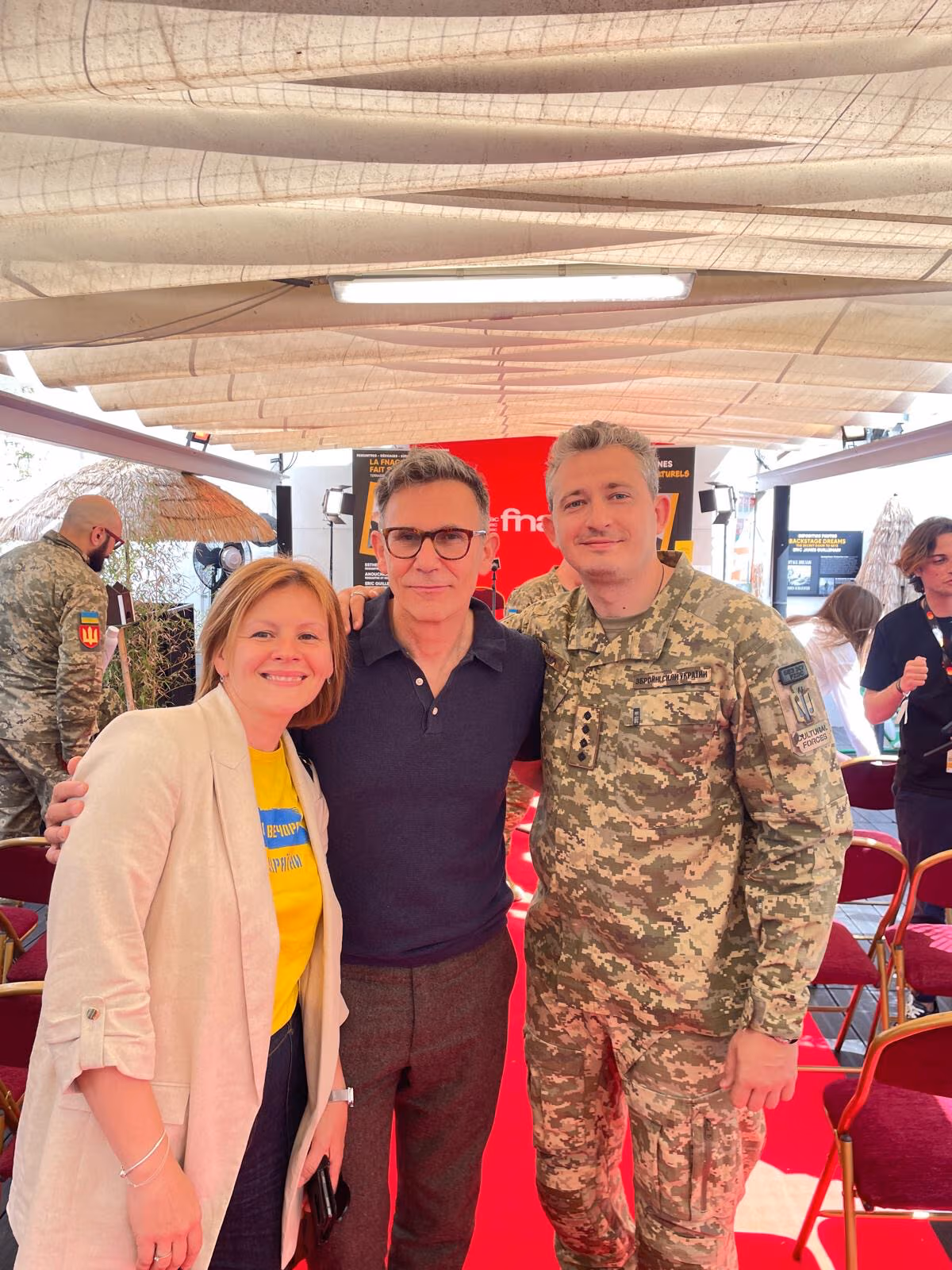 Iryna Podyryako-Bourdelles with director Michel Hazanavicius and a Ukrainian soldier at the Cultural Forces event.