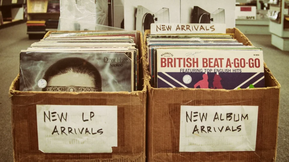 Explore a vintage record store with boxes of new LP and album arrivals.