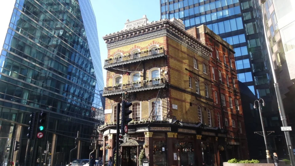 A historic pub in London juxtaposed with modern skyscrapers, capturing the city's blend of tradition and progress.