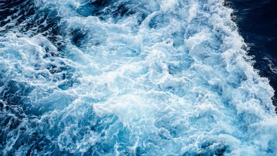 Aerial view of powerful ocean waves crashing, showcasing natural water patterns and textures.