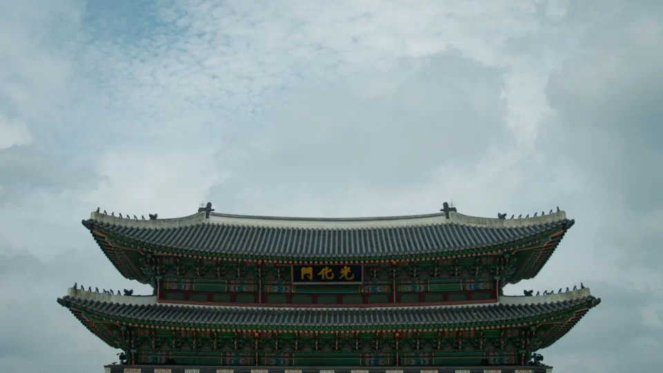 Historic Gyeongbokgung Palace main gate under a cloudy sky in Seoul, South Korea.