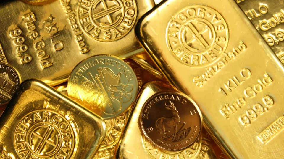 Close-up of shiny gold bars and coins, representing wealth and fortune.