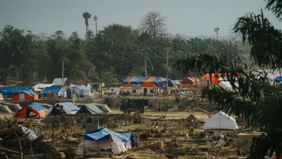 Temporary shelters in a disaster relief camp nestled in lush greenery in Aceh, Indonesia.