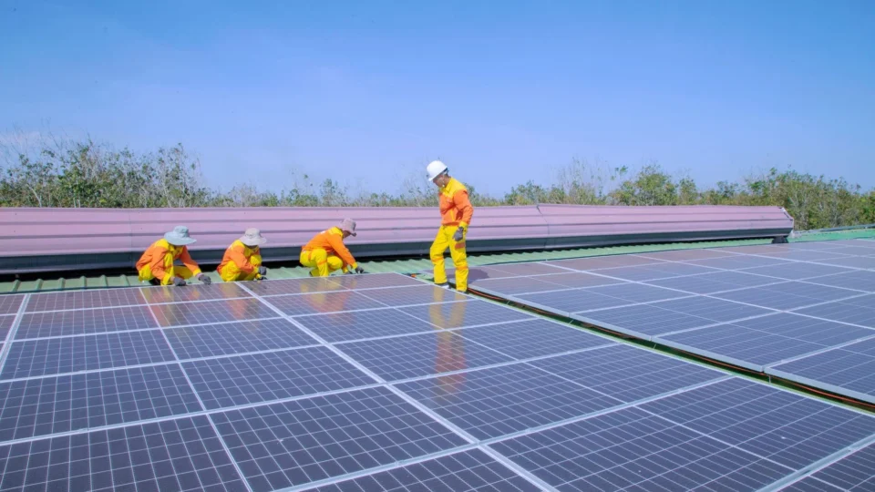 Workers install solar panels on a rooftop, promoting renewable energy and sustainability.