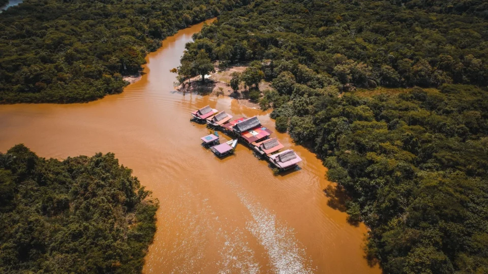 A stunning aerial view of a tranquil village situated on the Amazon River, surrounded by lush Peruvian rainforest.