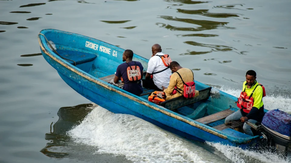 Group of men in a blue motorboat navigating the waters of Lagos, Nigeria.