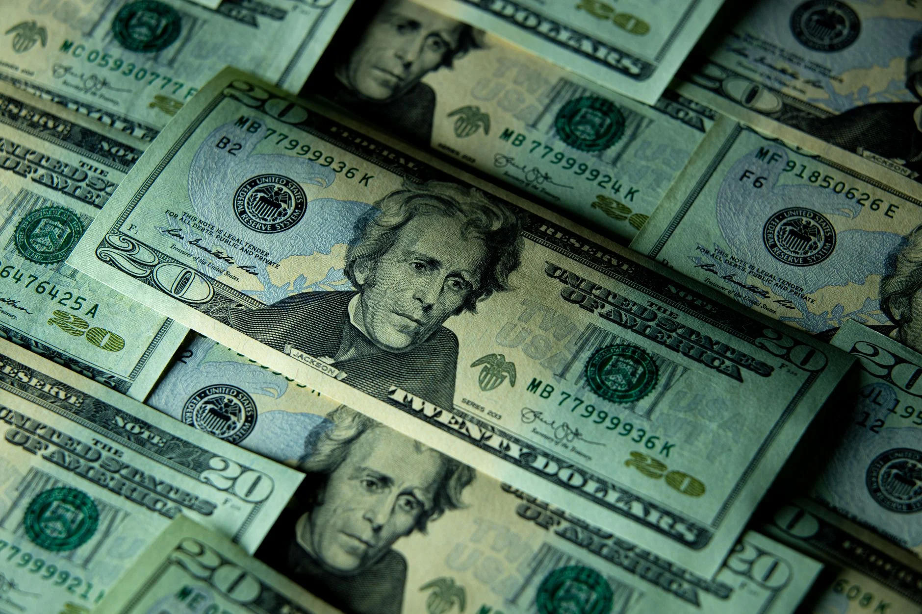 Close-up of multiple US twenty dollar bills depicting wealth and finance.