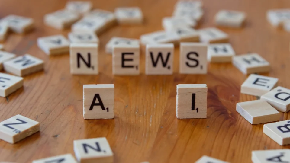 Wooden Scrabble tiles spelling 'AI' and 'NEWS' for a tech concept image.
