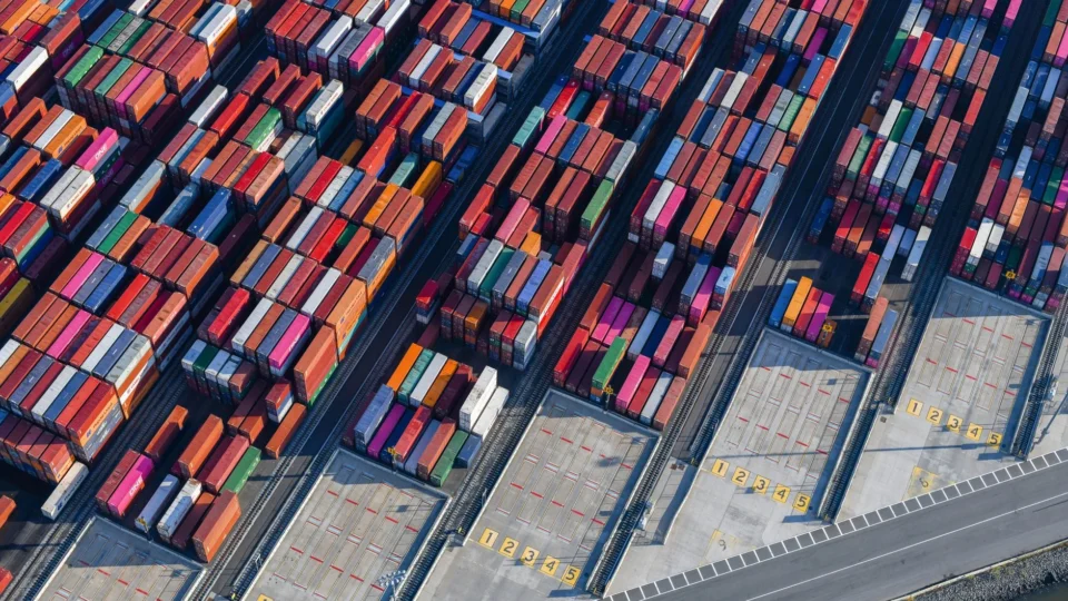 Aerial shot of colorful cargo containers at a bustling New York port, showcasing global trade.