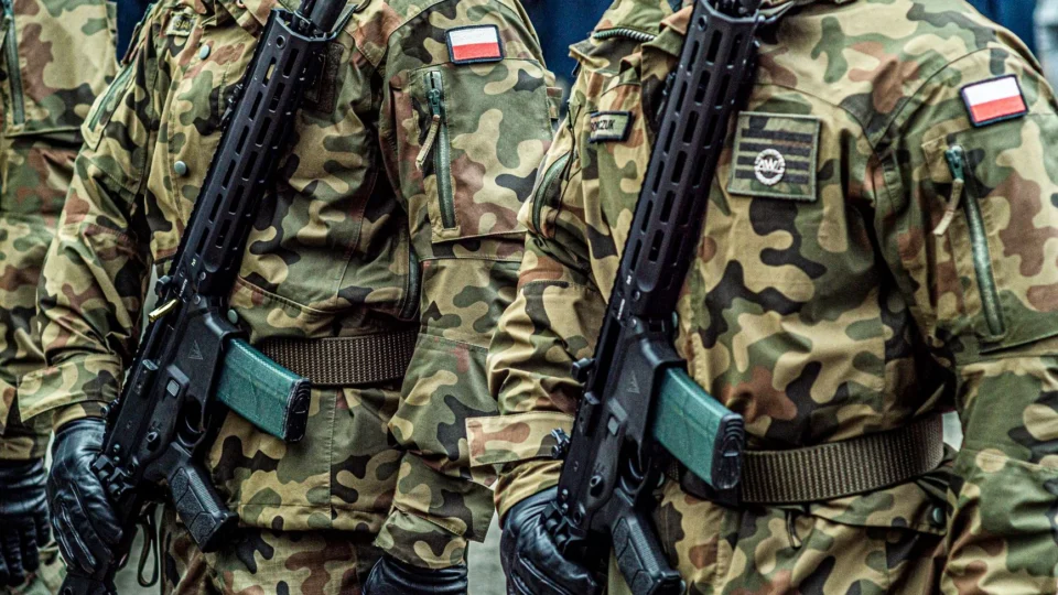 Polish soldiers in uniform standing in formation with rifles, showcasing military discipline.