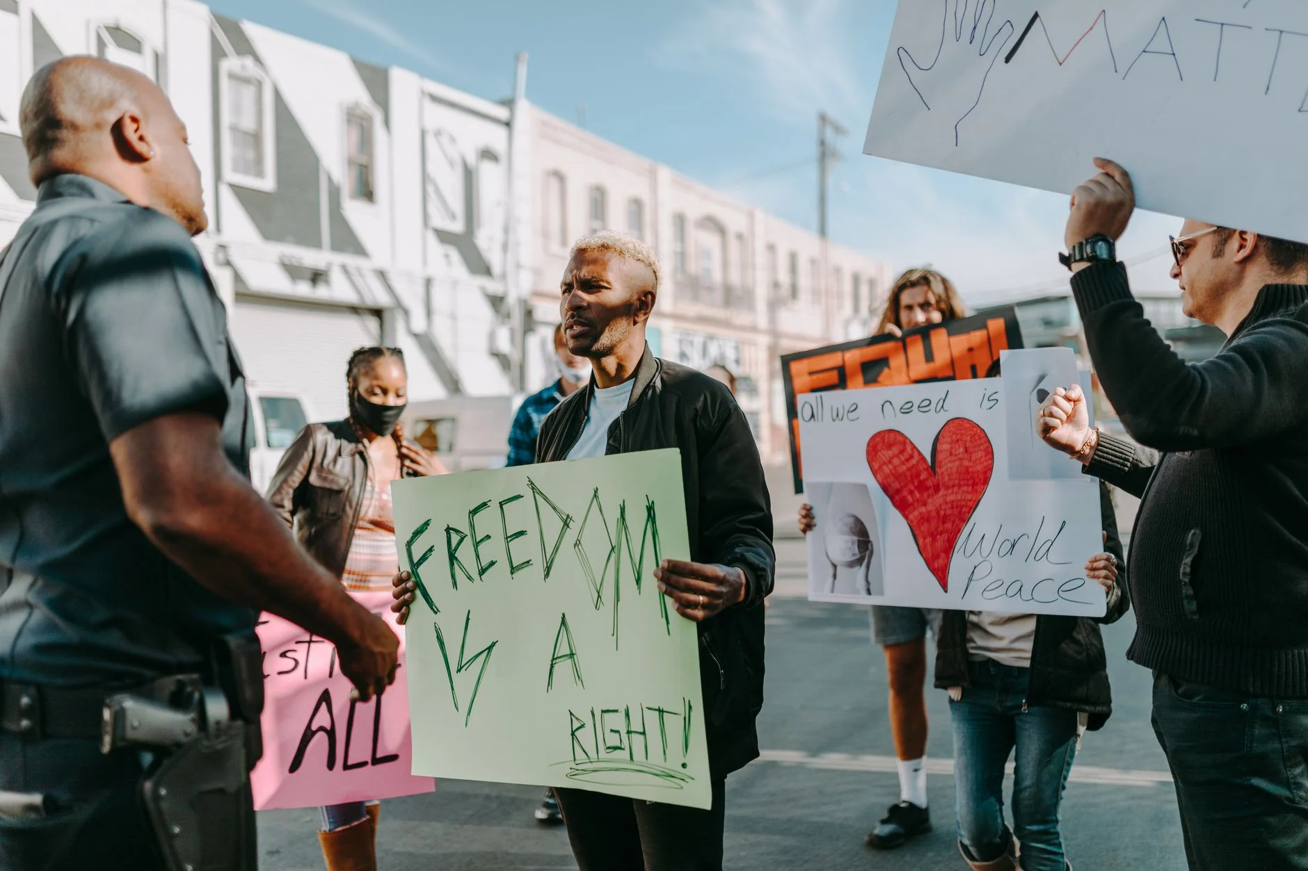 A diverse group of people peacefully protesting for freedoms and world peace in an urban setting.