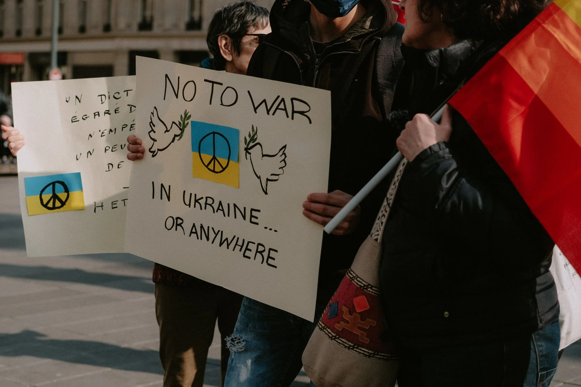Protesters holding signs advocating for peace in Ukraine and worldwide.