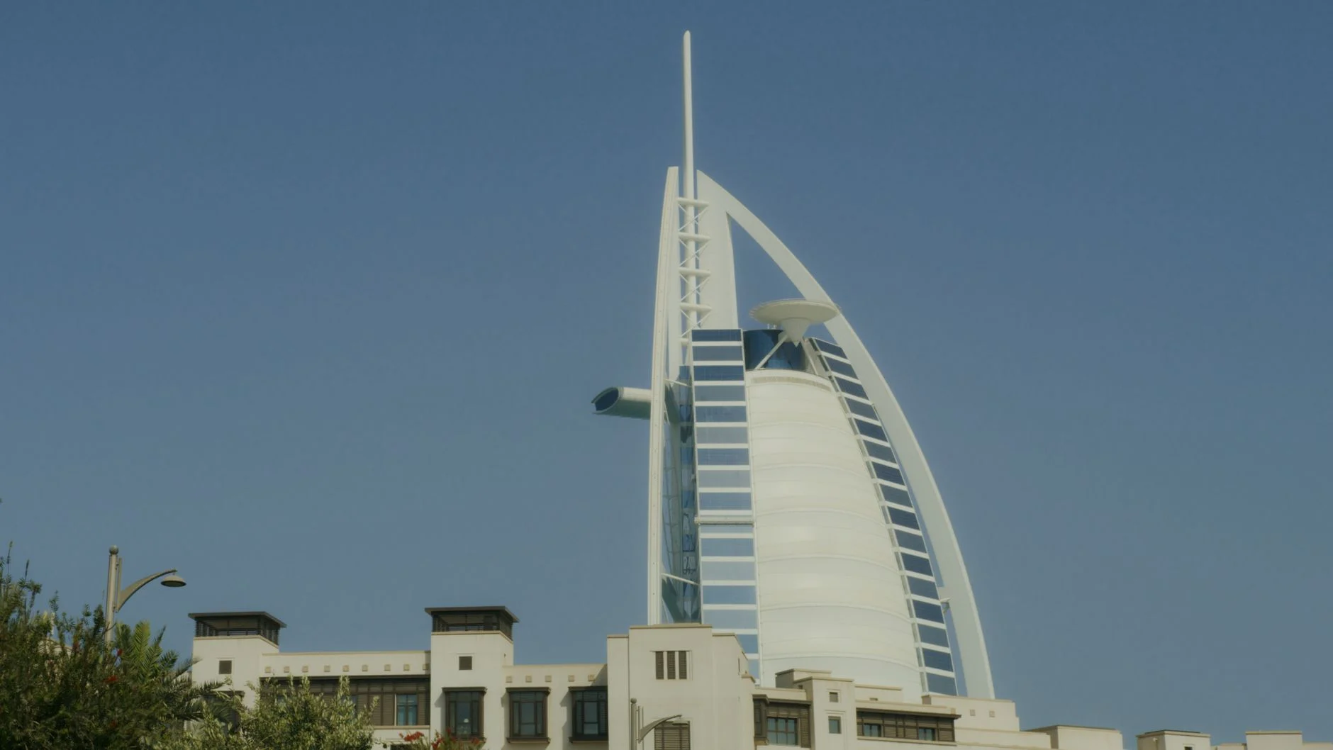 Iconic Burj Al Arab tower standing tall in Dubai under a clear blue sky.