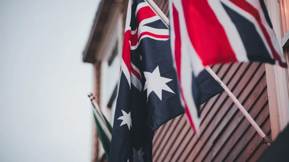 Close-up of Australian and British flags on a building's wooden exterior, signifying national pride.