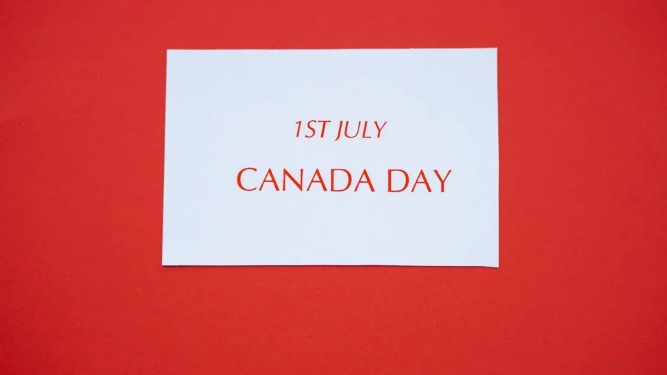 A white card with red text displaying '1st July Canada Day' on a red background.