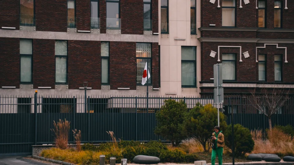 Exterior of the Japanese Embassy in Kyiv, featuring the national flag and urban landscape.