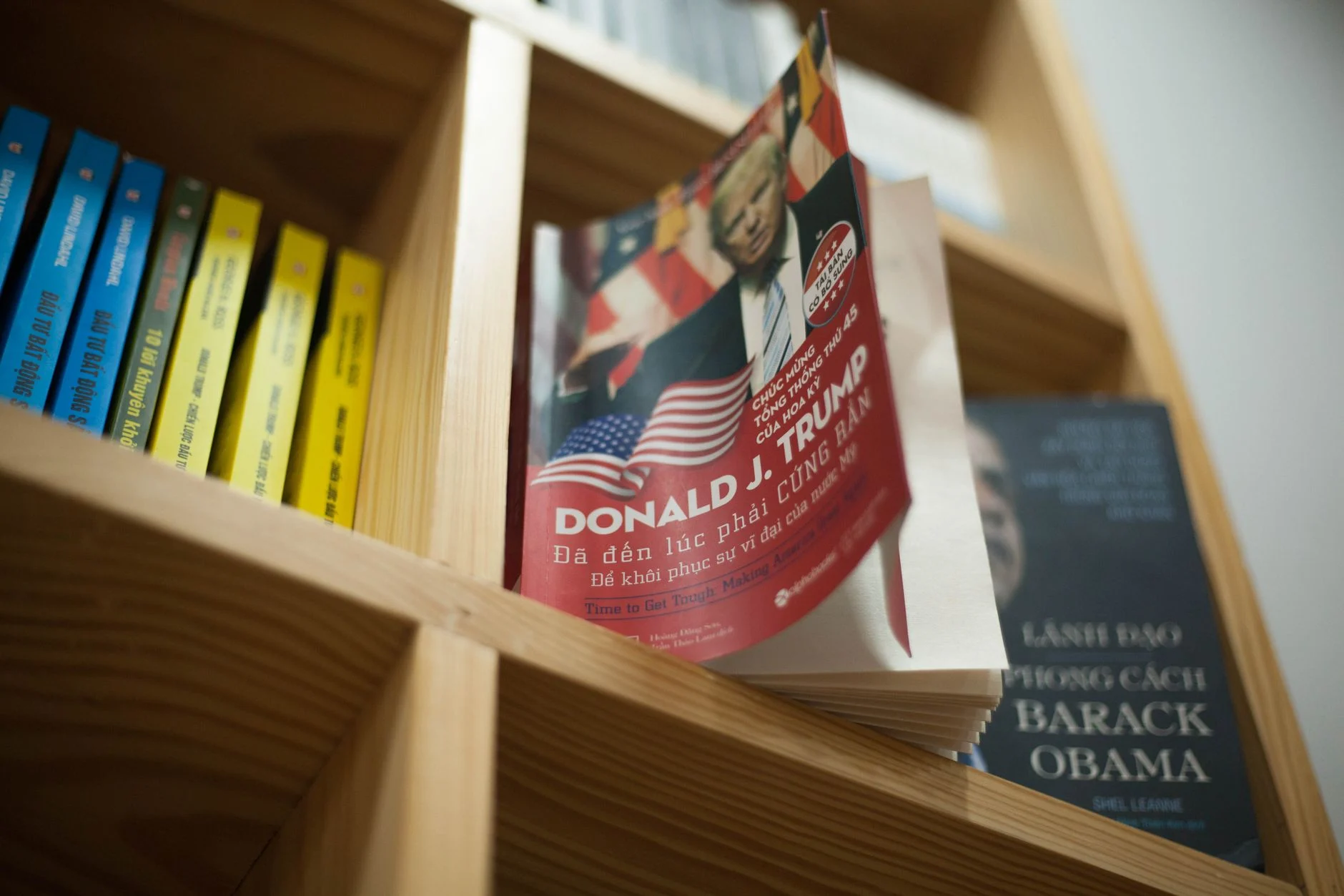 A close-up view of a bookshelf with books featuring political leaders in a bookstore setting.
