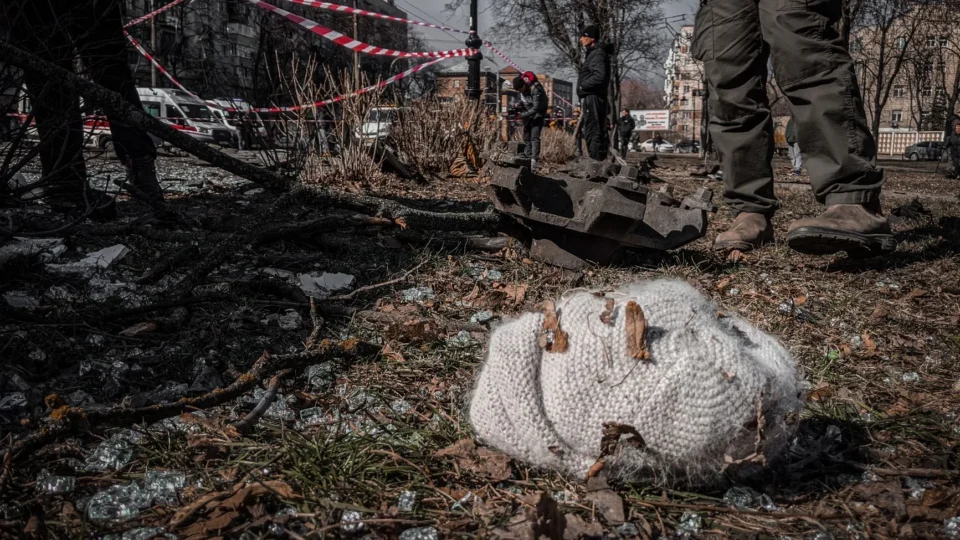 A chaotic urban scene depicting destruction with a knitted hat lying on the ground in Kyiv, Ukraine.