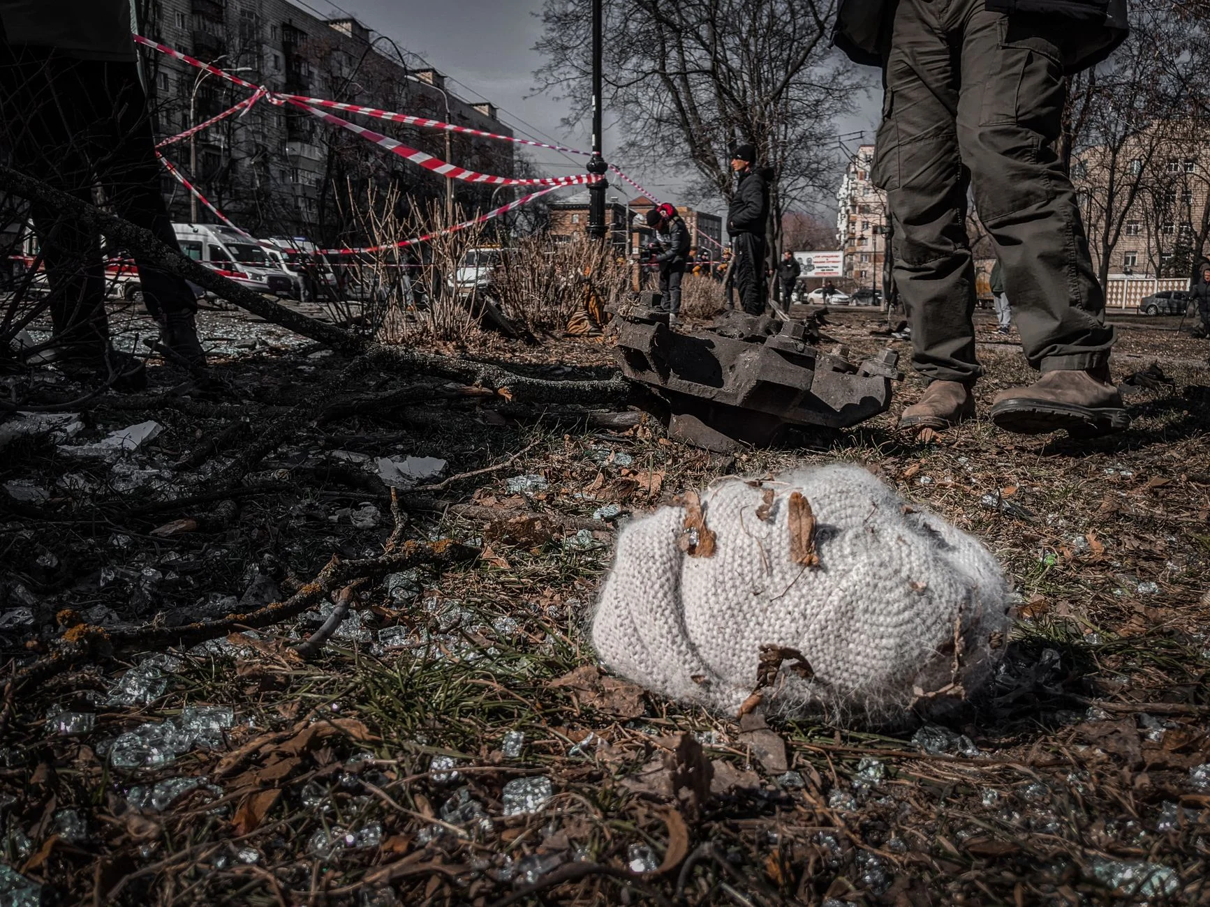 A chaotic urban scene depicting destruction with a knitted hat lying on the ground in Kyiv, Ukraine.
