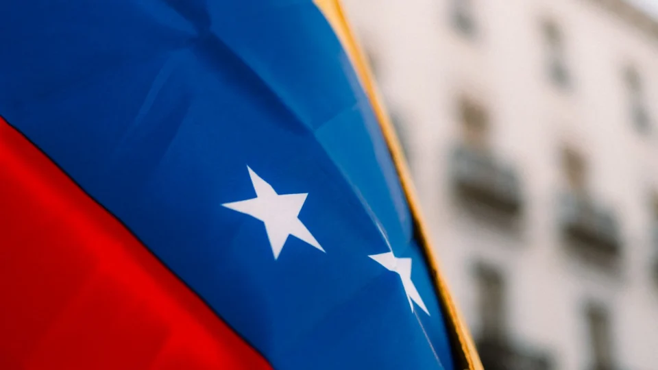 Close-up of the vibrant Venezuelan flag with stars in an urban environment, symbolizing national pride.