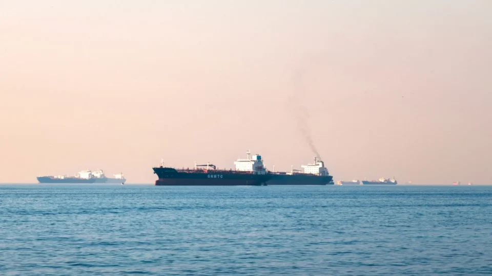 Large industrial tanker ships navigating the open sea under a clear sky, illustrating maritime transportation.