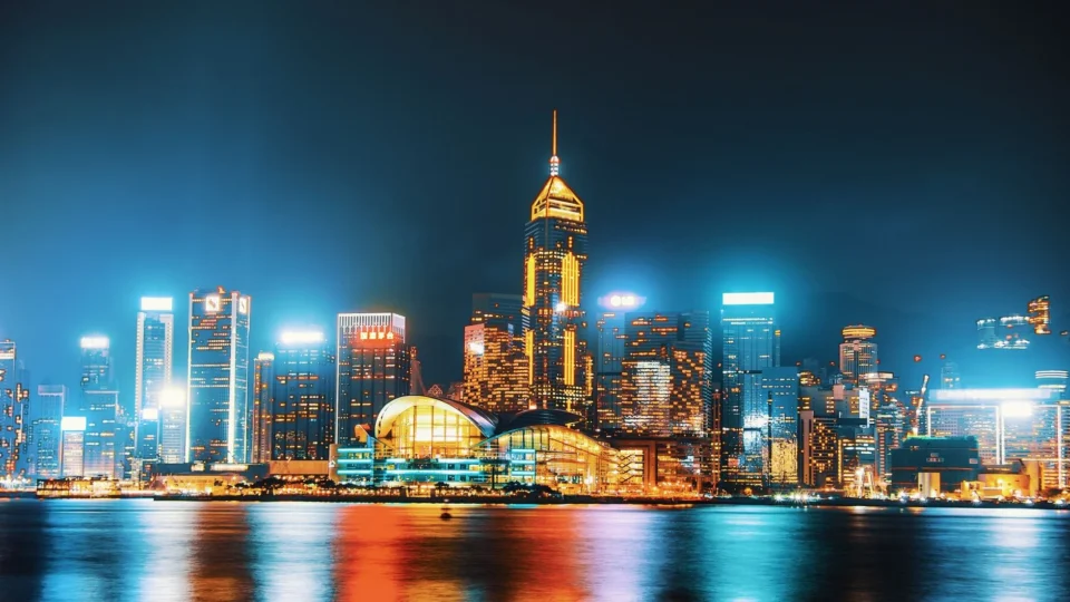 Vivid Hong Kong skyline at night featuring illuminated skyscrapers and waterfront reflections.
