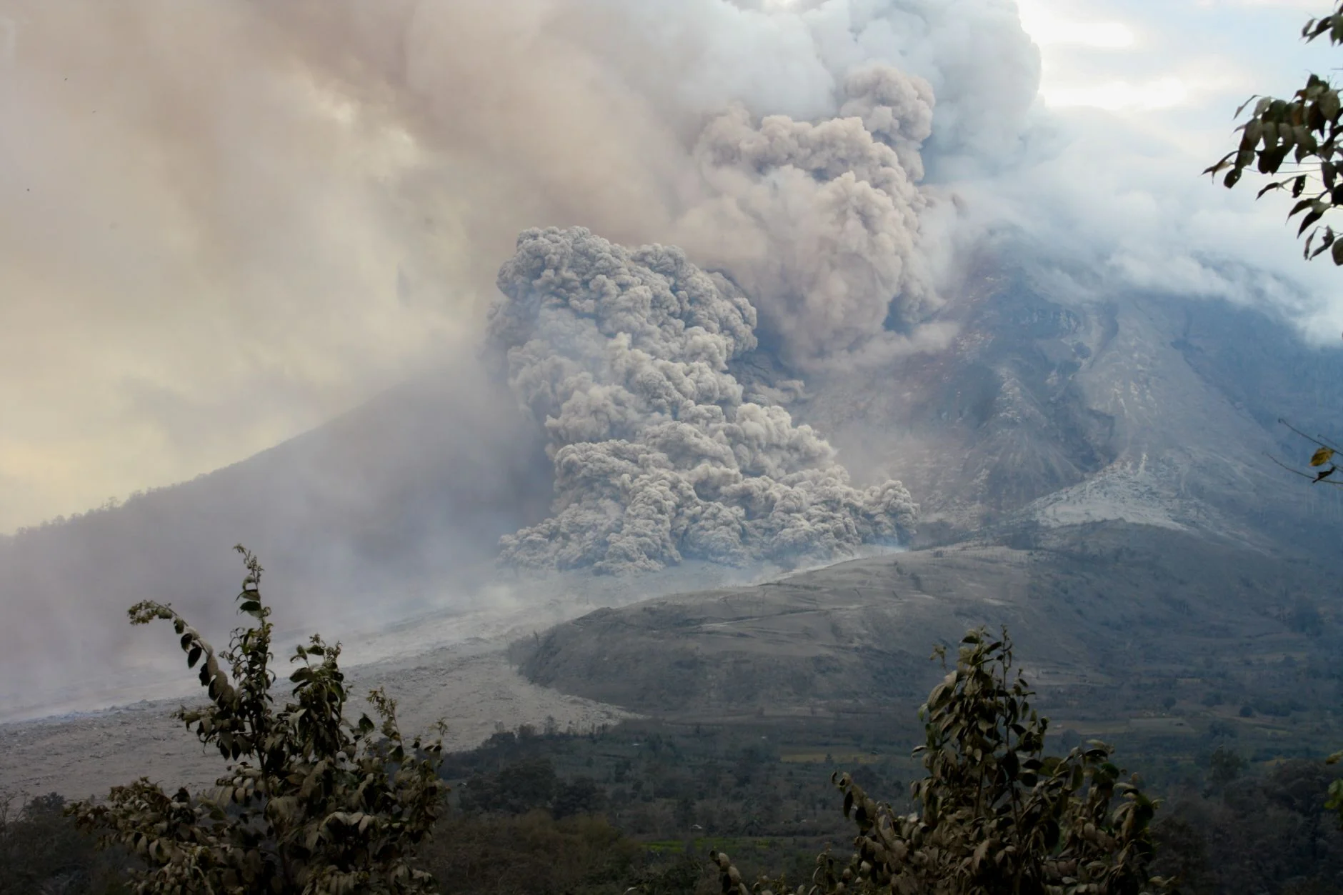 A powerful eruption of Mount Sinabung in North Sumatra, Indonesia, showcasing volcanic smoke and ash clouds.