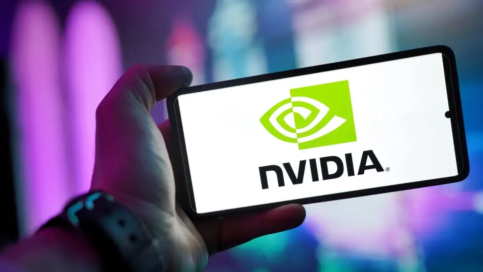 Hands holding a smartphone showing the NVIDIA logo on a bright screen.