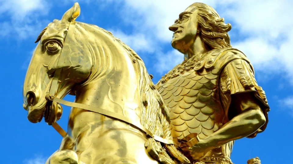 Close-up of the Golden Rider statue in Dresden with vibrant blue sky.